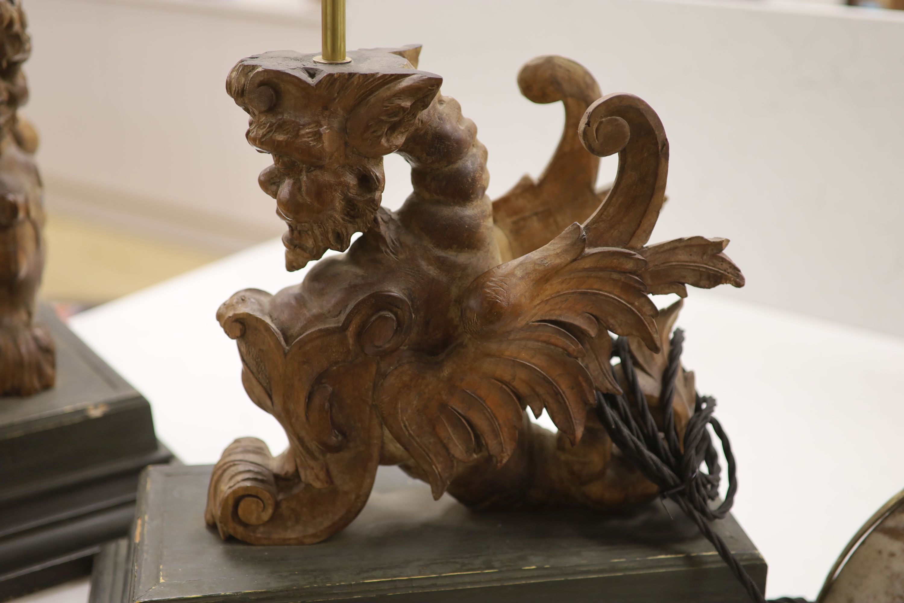 A pair of carved walnut winged griffin table lamps, 40cm high excl. light fitting